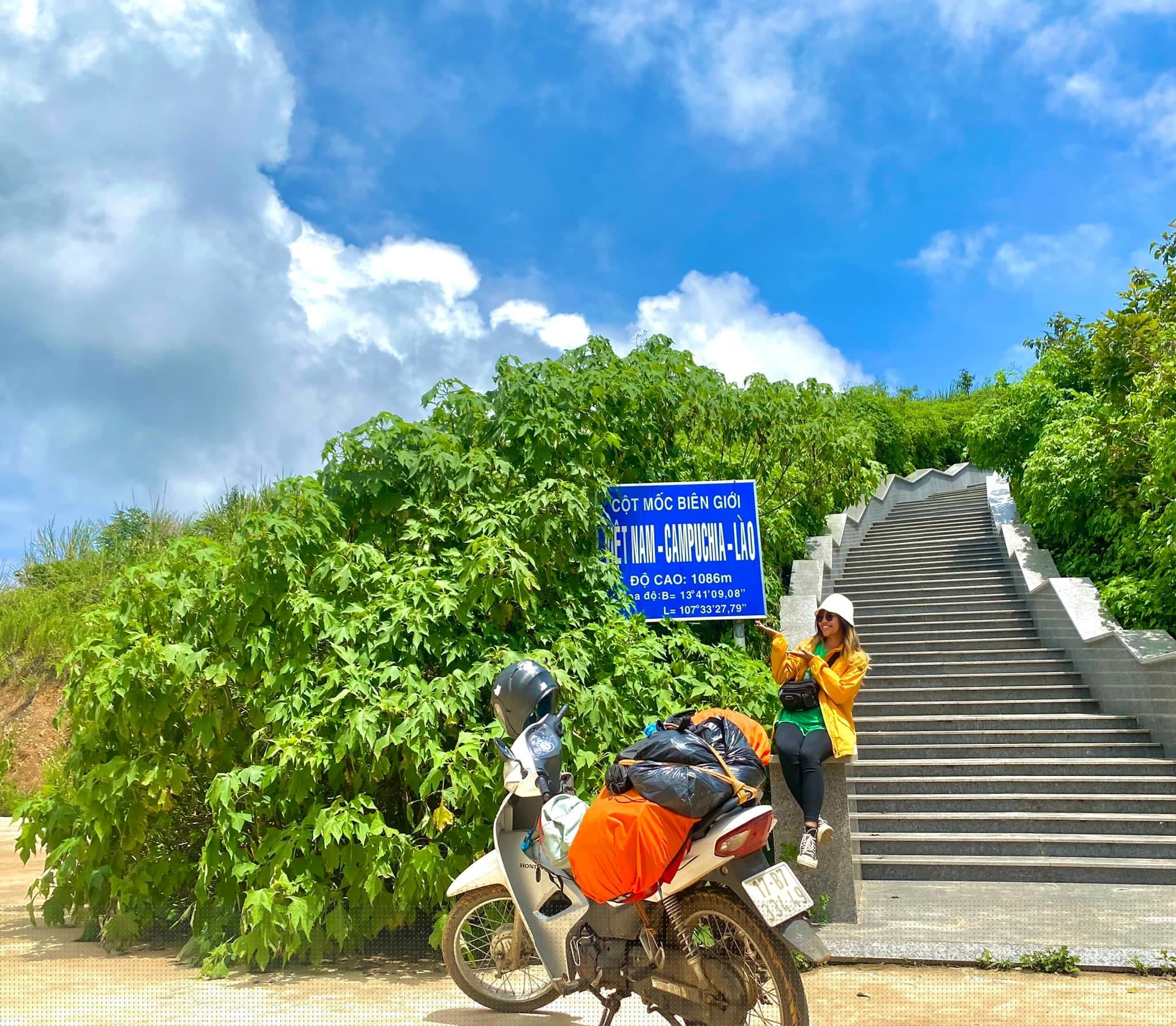 Có thể là hình ảnh về 2 người, xe môtô, cây và đường